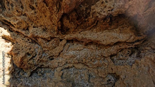 Wallpaper Mural 360 rotation. The sun shines through a rock arch, casting a warm glow on the rugged landscape. The rock textures contrast with the clear blue sky, creating a picturesque and natural frame. Torontodigital.ca