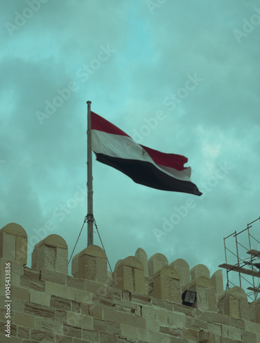 Egyptian Flag Waving Over Historic Fort in Alexandria Egypt photo