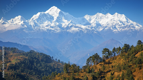 Snow capped peaks of the Himalayas with lush green hills in the foreground under a clear blue sky