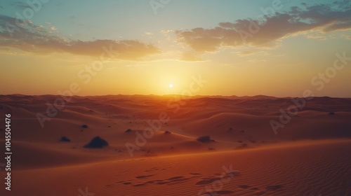 Golden Sunset Over the Desert Landscape with Soft Clouds and Dune Shadows