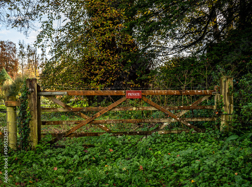 Closed wooden rural gate with a private sign attached.