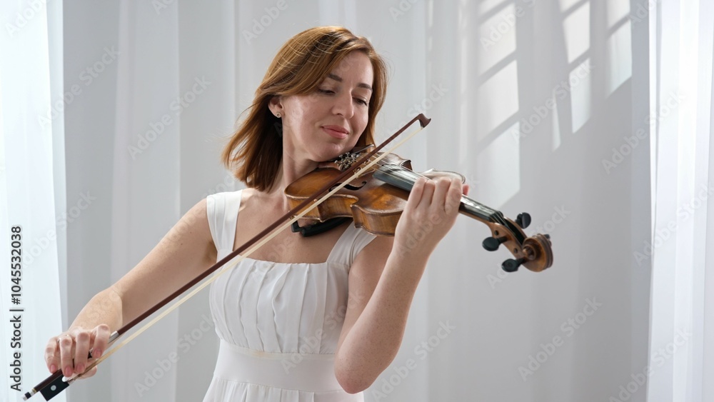 Elegant woman in white dress playing violin in bright minimalist style Elegant woman in white dress playing violin in bright minimalist style