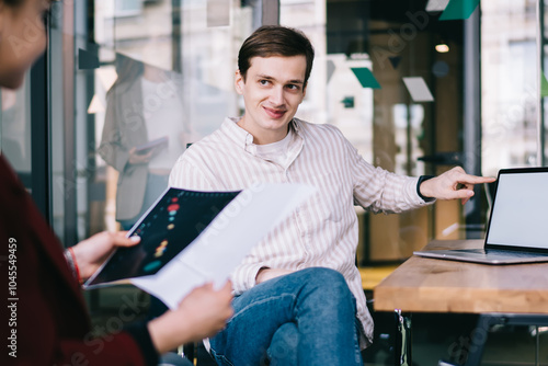 Happy entrepreneur demonstrating screen of laptop to customer