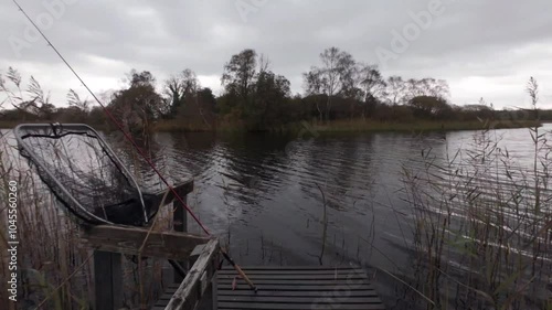 Dramatic cloudy lakeside landscape scenery, fishing dock at Ballyquirke lough, Moycullen, Galway, Ireland photo