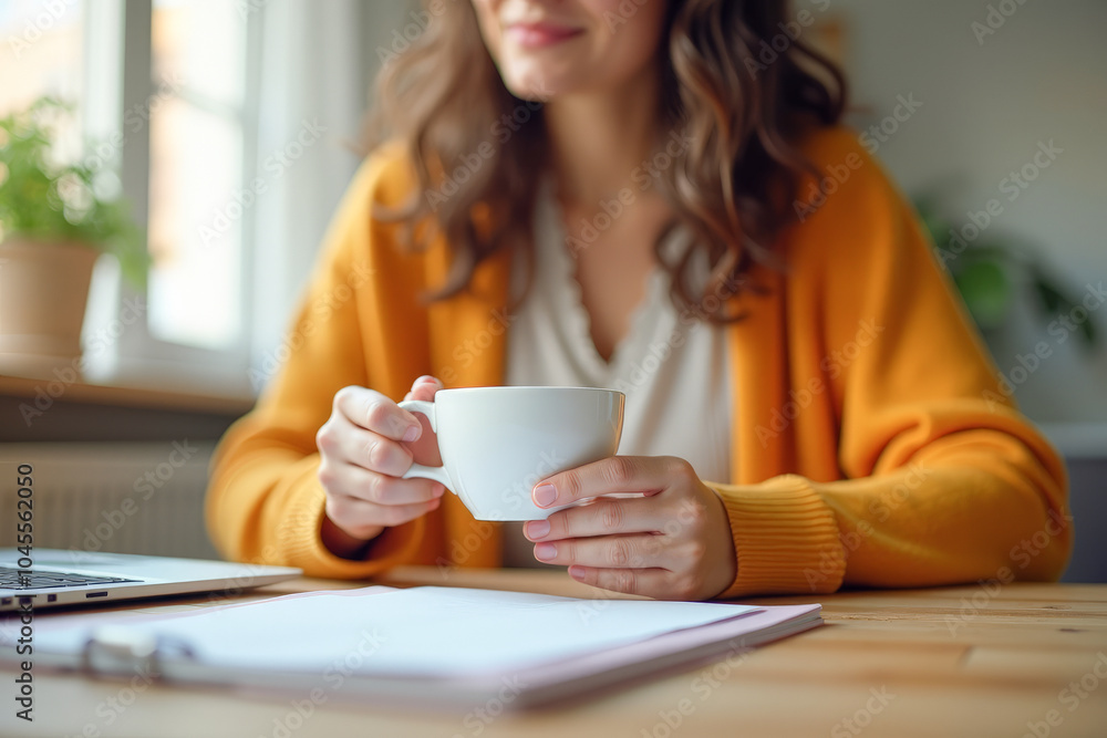 a woman drinks coffee tea at a table with a laptop close-up a woman drinks coffee tea at a table with a laptop close-up