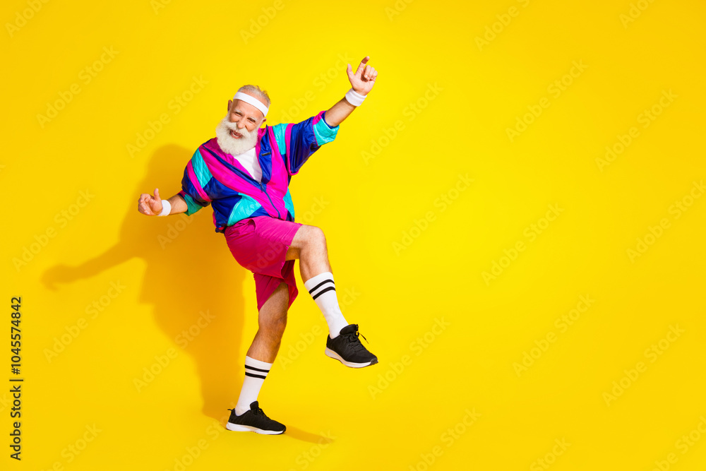 Full length photo of handsome good mood senior guy oldschool sportswear having fun emtpy space isolated yellow color background Full length photo of handsome good mood senior guy oldschool sportswear having fun emtpy space isolated yellow color background