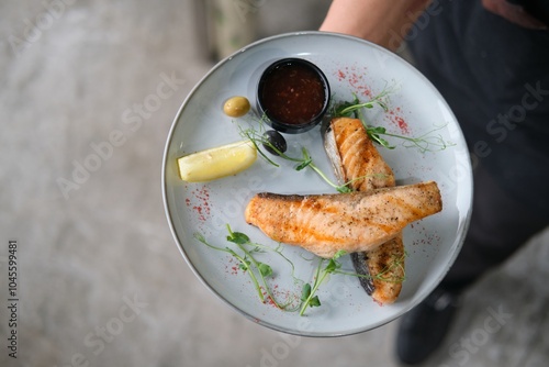 Chef Garnishing Grilled Fish with Herbs photo