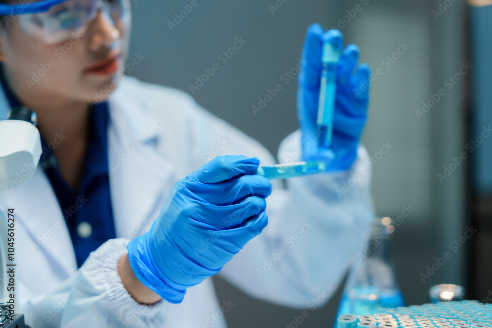 Scientist wearing gloves is carefully extracting a sample from a test tube in a laboratory setting Scientist wearing gloves is carefully extracting a sample from a test tube in a laboratory setting