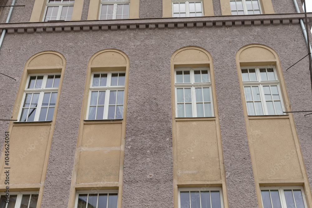 A large and impressive building featuring numerous windows throughout its facade, which enhances its architectural appeal and functionality A large and impressive building featuring numerous windows throughout its facade, which enhances its architectural appeal and functionality