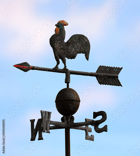 rooster weather vane with cardinal directions shows wind direction using an arrow to point the way the wind is blowing photo