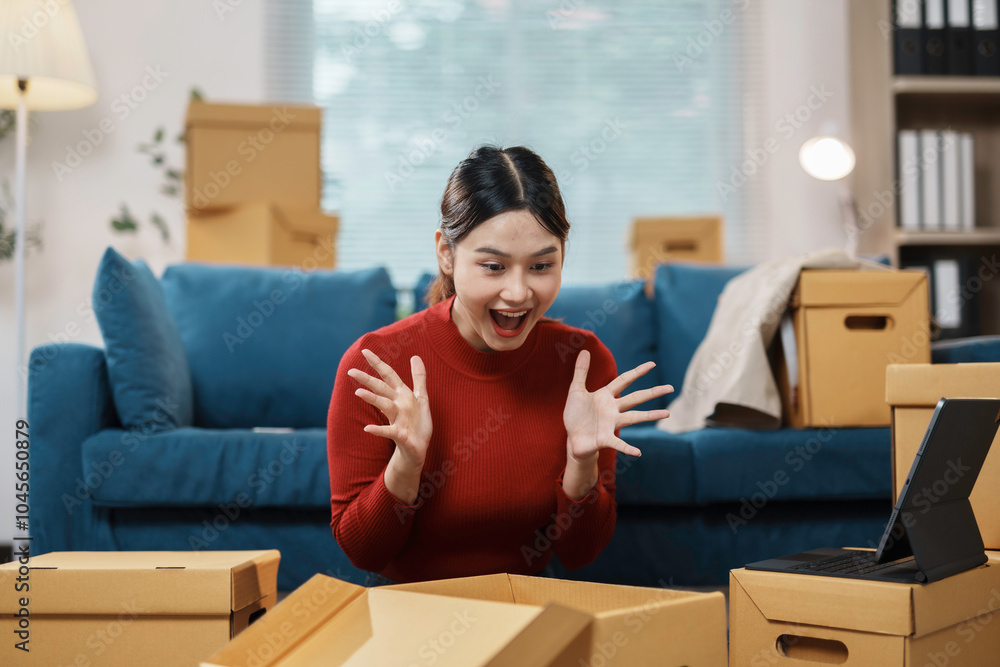 Young woman is unpacking boxes in her new home and having a video call, excited about the experience Young woman is unpacking boxes in her new home and having a video call, excited about the experience