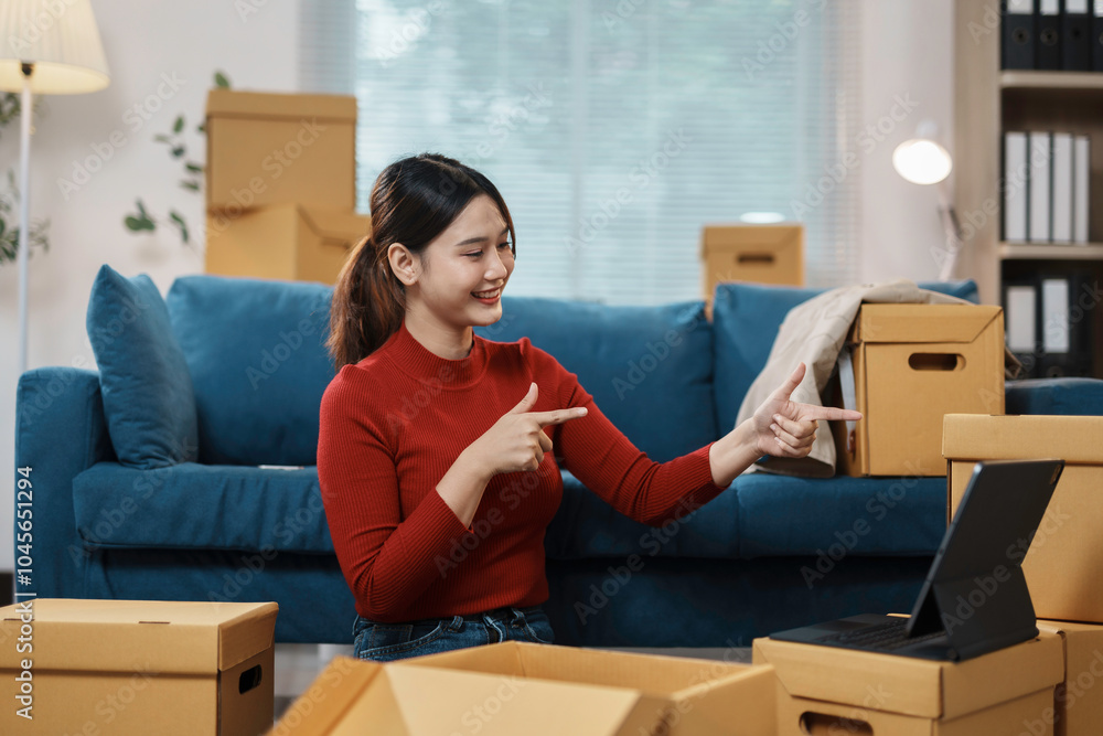 Young woman sitting on the floor surrounded by cardboard boxes is having a video call Young woman sitting on the floor surrounded by cardboard boxes is having a video call