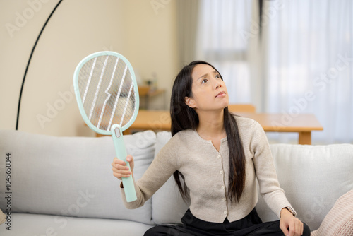 Fotografía Woman use mosquito swatter at home