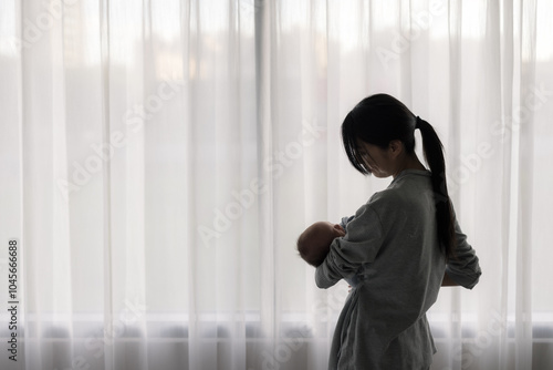 Mom hold with her baby and standing besides the curtain at home Free Download Mom hold with her baby and standing besides the curtain at home - GFXLoad