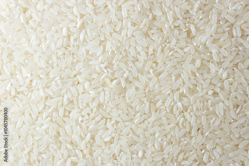 Dry Uncooked White Rice Background - Top View, Flat Lay. Scattered Raw Long Grain Rice. Asian Cuisine and Culture. Healthy Eating Ingredients. Diet Food