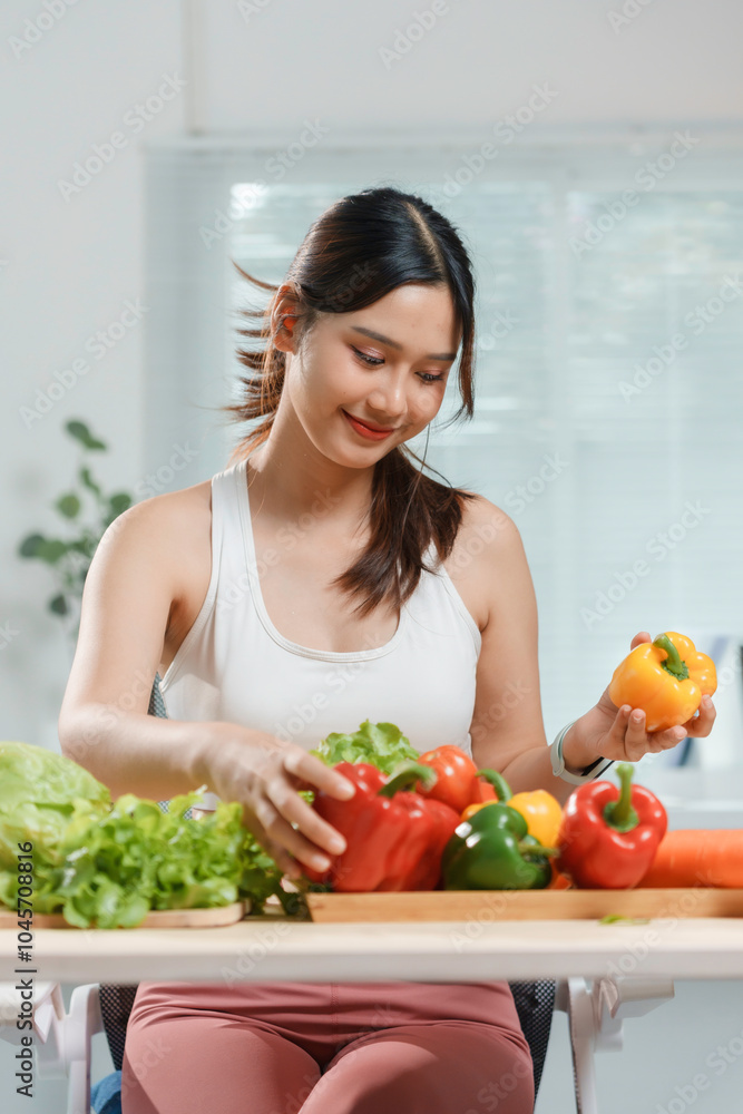 Young woman is smiling while preparing a healthy meal with fresh vegetables in her kitchen Young woman is smiling while preparing a healthy meal with fresh vegetables in her kitchen