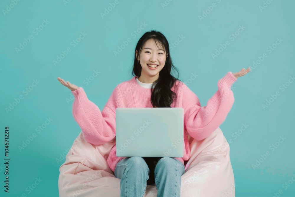 A person sitting comfortably on a bean bag chair, using a laptop A person sitting comfortably on a bean bag chair, using a laptop
