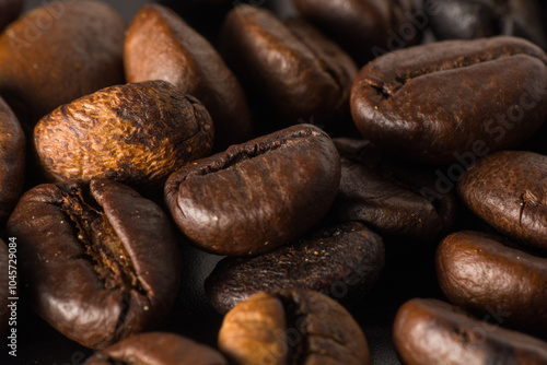 Close-up image of rich, dark roasted coffee beans, showcasing texture and color.