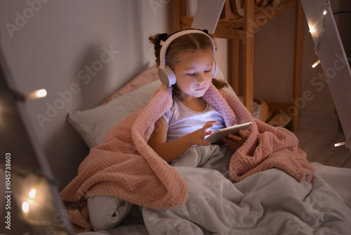 Cute little girl using tabl...