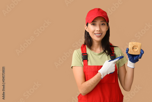 Young female electrician po...