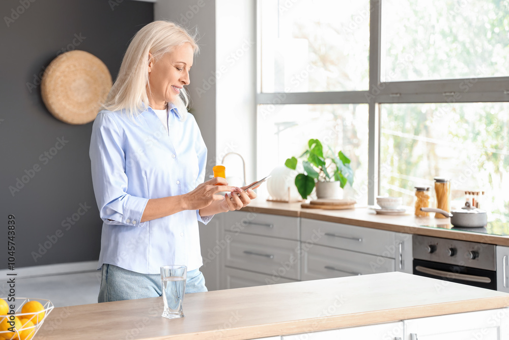 Mature woman checking pills description online in kitchen Mature woman checking pills description online in kitchen