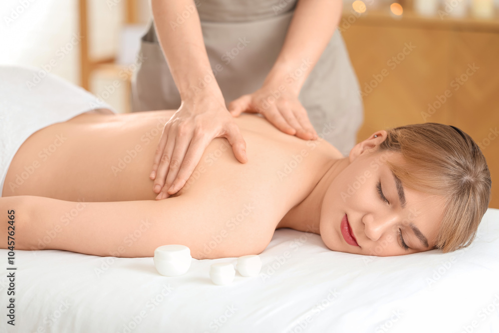 Young woman undergoing massage procedure in spa salon Young woman undergoing massage procedure in spa salon