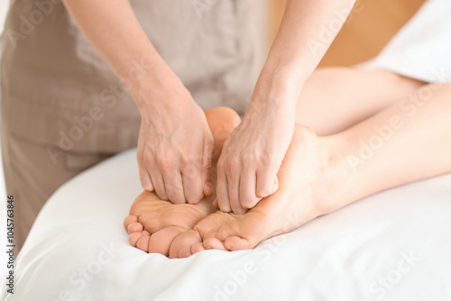 Woman receiving feet massage in spa salon