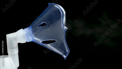 Nebulizer Inhaler mask close-up vaporizer on black background. Medical device. Treatment of colds. Macro, close up