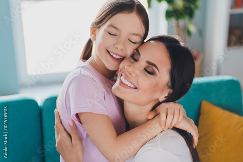 Portrait of happy family lovely mother with daughter hugging indoors cozy living room