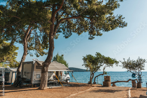 Family traveling with motorhome. Camping in Greece at dawn. Camping holiday at sea.