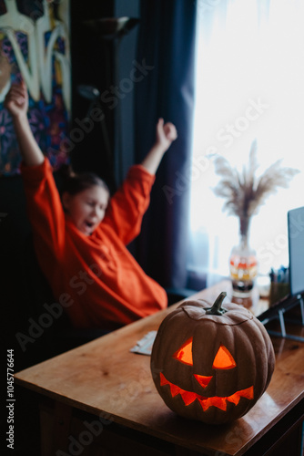 Wallpaper Mural Caucasian happy girl orange color cloths near carved Halloween pumpkin studying online laptop Torontodigital.ca