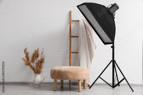 Modern photo studio with pouf and professional lightening equipment photo