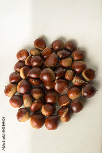 Chestnuts with a white background in a top view, freshly picked, ready to be consumed vertically