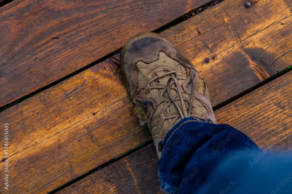 A worn sneaker resting on a weathered wooden deck during a sunny afternoon adventure A worn sneaker resting on a weathered wooden deck during a sunny afternoon adventure