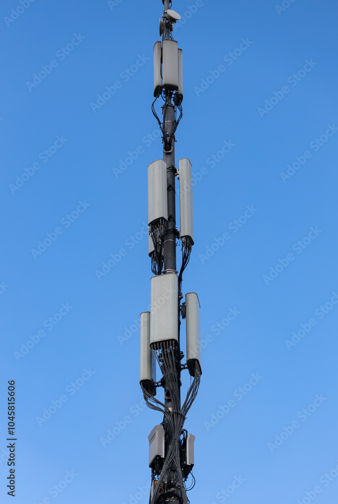 A tall communication tower stands under a clear blue sky in a rural area, symbolizing connectivity and progress A tall communication tower stands under a clear blue sky in a rural area, symbolizing connectivity and progress
