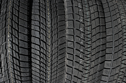 Closeup image of textured pattern of directional tread blocks and large sipes on winter non studded tires
 photo