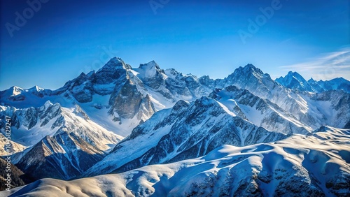 Snowy mountain range under clear blue sky with depth of field effect