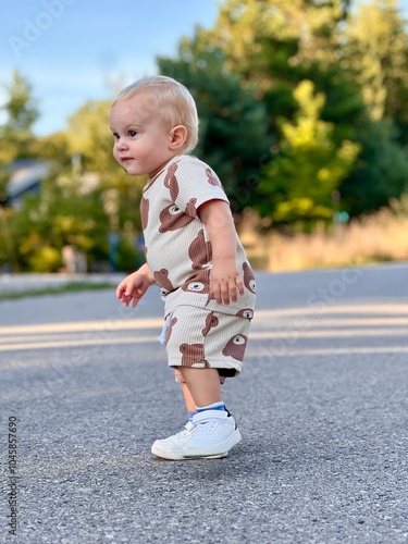 Happy Toddler Outdoors in Cute Bear-Print Outfit Enjoying a Sunny Day