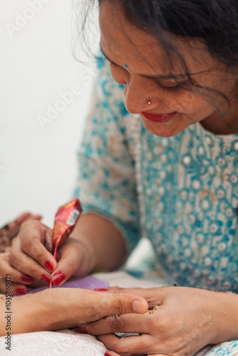 A woman applied henna to another woman's hand for the Karwa Chauth festival. photo