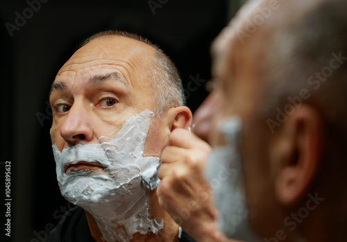 Man shaves wet at home with razor blades photo