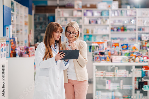 Obraz na plátně Pharmacist showing information on digital tablet to customer in drugstore