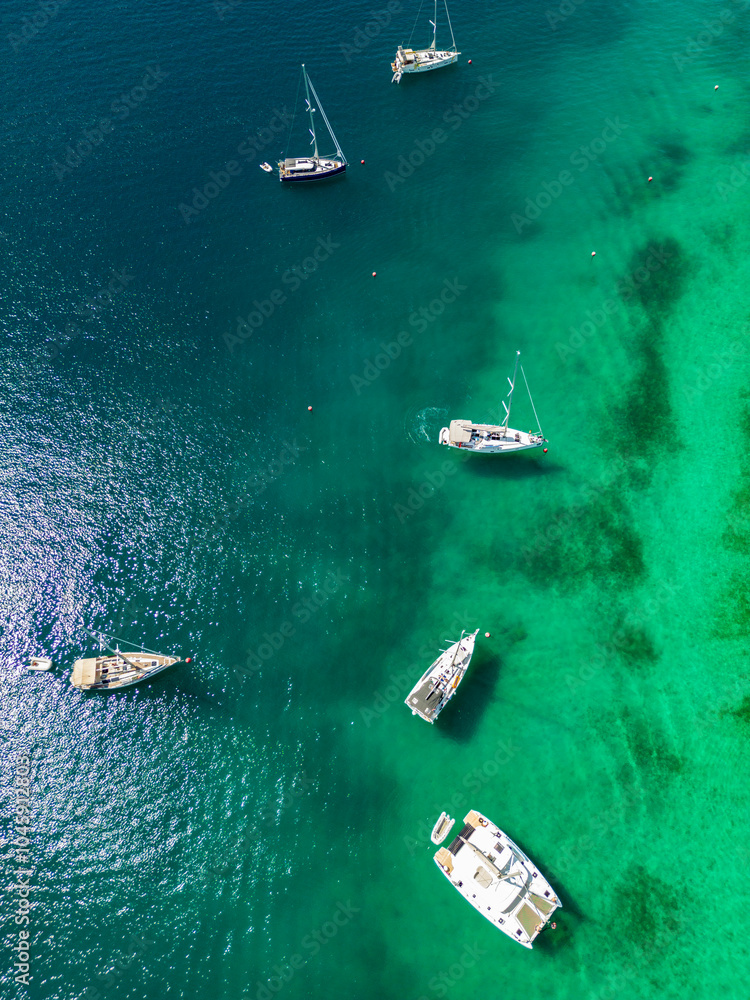 Fototapeta premium Drone top down view on sailing boats anchored in beautiful, crystal clear waters of Rogoznica, Croatia, famous nautical destination in the adriatic sea