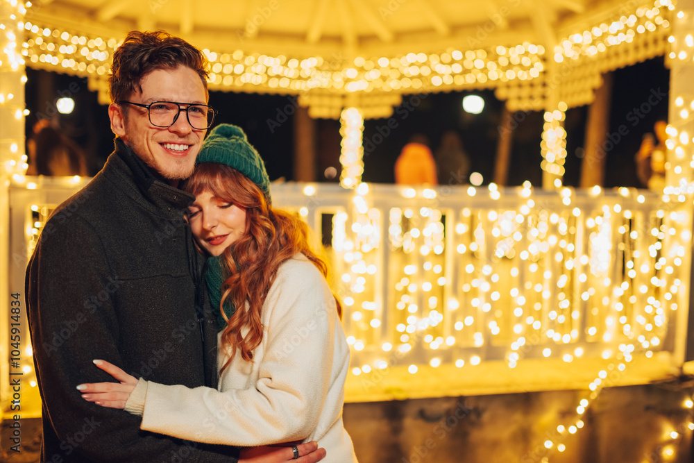 A festive loving couple is hugging on city street on christmas eve. A festive loving couple is hugging on city street on christmas eve.
