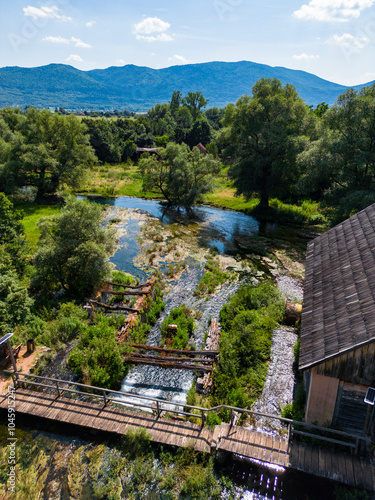 Aerial view of Gacka river valley, surrounded by mountains and forests in mountain region of Lika, Croatia