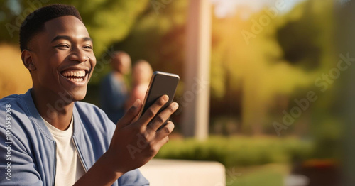 Smiling young man holding a smartphone in his hands