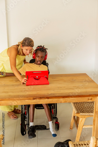 Young boy with cerebral palsy learning with teacher at home