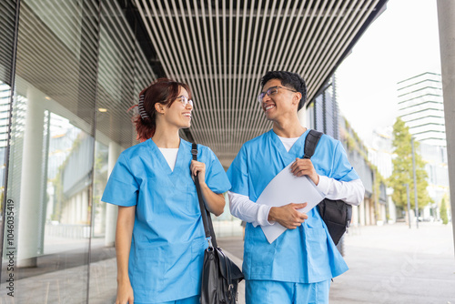 Two nursing students chatting joyfully in a modern campus setting