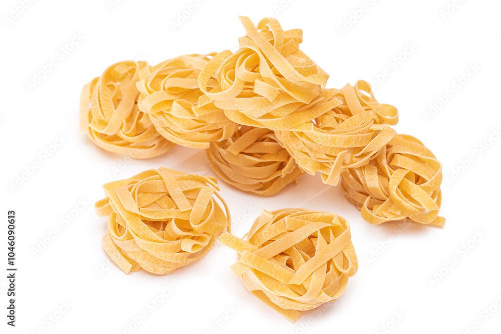 A Pile of Classic Italian Raw Egg Fettuccine - Isolated on White Background. Dry Twisted Uncooked Pasta. Italian Culture and Cuisine. Raw Golden Macaroni Pattern - Isolation A Pile of Classic Italian Raw Egg Fettuccine - Isolated on White Background. Dry Twisted Uncooked Pasta. Italian Culture and Cuisine. Raw Golden Macaroni Pattern - Isolation