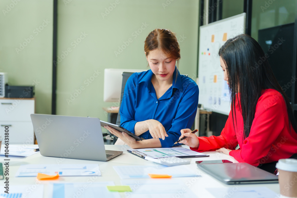 Two young female business consultants work on startup, collaborating on mobile app development social media strategies. whiteboards, documents, they aim to build a successful e-commerce business. Two young female business consultants work on startup, collaborating on mobile app development social media strategies. whiteboards, documents, they aim to build a successful e-commerce business.