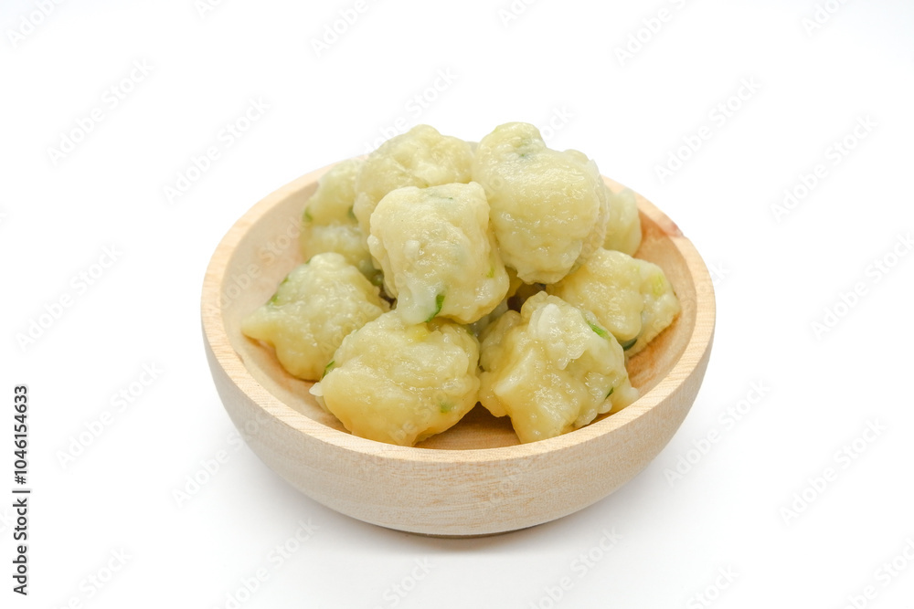 Homemade siomay with soft and chewy texture served in wooden bowl isolated on white background. Homemade siomay with soft and chewy texture served in wooden bowl isolated on white background.